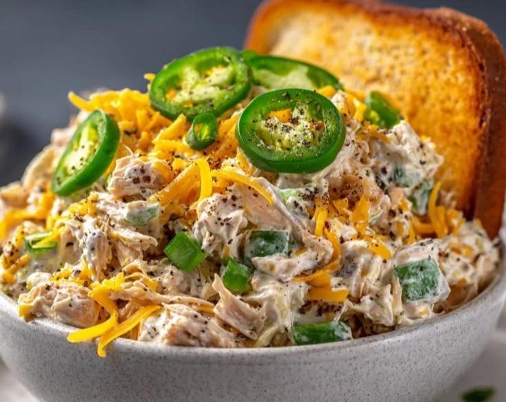 Delicious bowl of Jalapeno Popper Chicken Salad topped with jalapenos and cheese